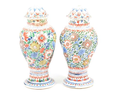 Pair of Chinese porcelain covered vases, clobbered decoration, spiral fluted body, lotus leaf domed covers, old damages and r