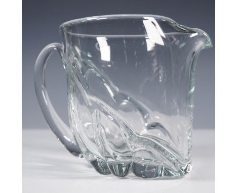 Clear glass water pitcher featuring an elegant organic form with a sculpted wave-like design and an integrated ice lip for ea