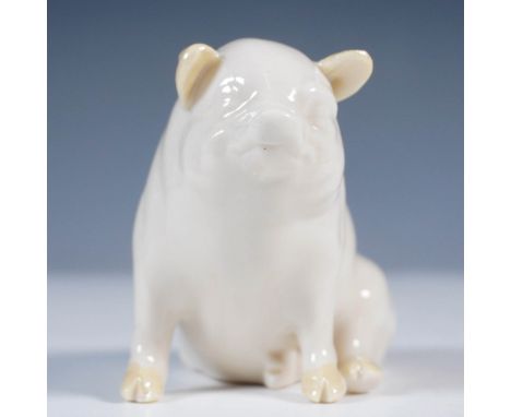 Charming Belleek porcelain figurine depicting a smiling pig, crafted in classic cream with soft yellow accents on the ears an