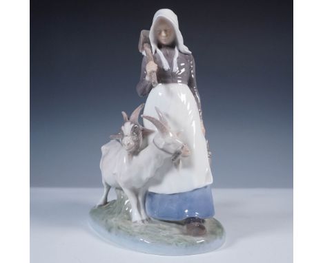 Crafted by Royal Copenhagen, this porcelain figurine (No. 694) features a serene pastoral scene of a woman leading two goats 