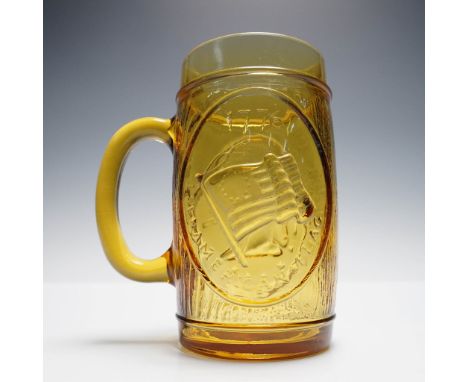 Amber glass beer stein featuring embossed patriotic scenes, including an image of Betsy Ross sewing the American flag. Design