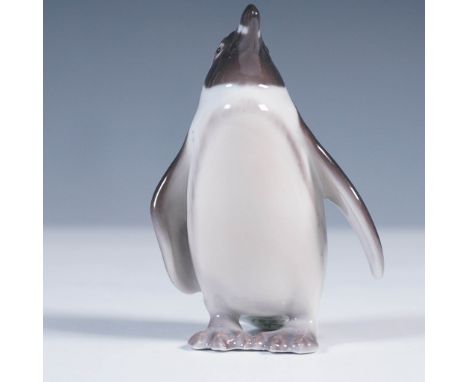 Crafted by the renowned Danish porcelain maker Bing &amp; Grondahl, this charming porcelain figurine features a penguin stand