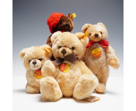 Adorable group of four Steiff plush teddy bears featuring a variety of soft, cuddly colors and signature design elements. The