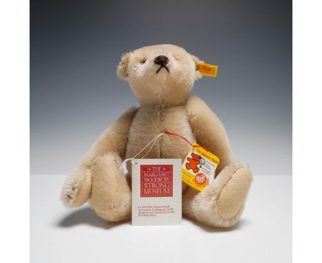 A collectible Steiff teddy bear made of genuine mohair, created in honor of The Margaret Woodbury Strong Museum. This cream-c