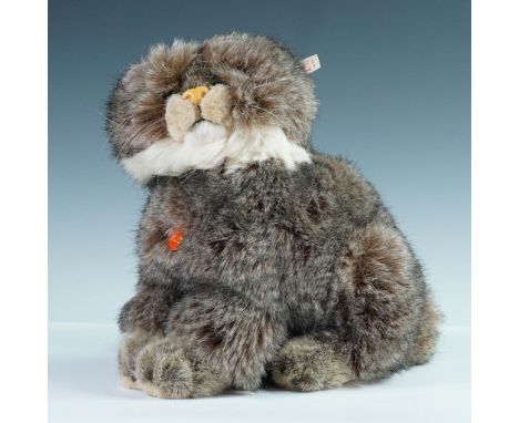 Authentic Steiff plush Pallas cat with long, soft faux fur in a naturalistic mottled gray and brown palette, complete with wh