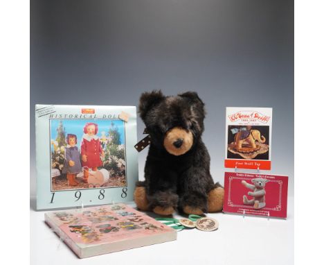Seven-piece collection featuring a plush Gund bear paired with a variety of collectible Steiff items and memorabilia. The sof