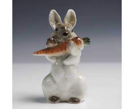 Charming Lomonosov porcelain figurine depicting a seated rabbit holding a large carrot. Hand-painted in soft gray, brown, and