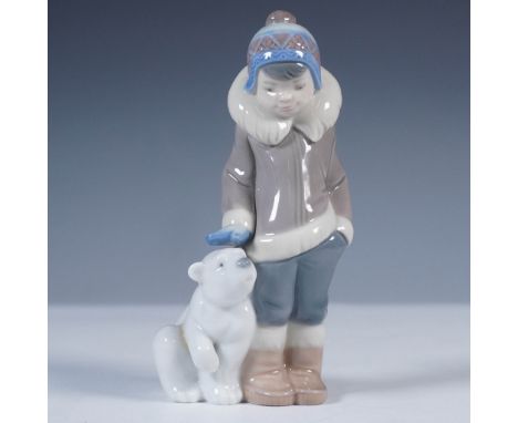 Hand-crafted in Spain by Lladro, this porcelain figurine depicts a young boy affectionately resting his hand on the head of a