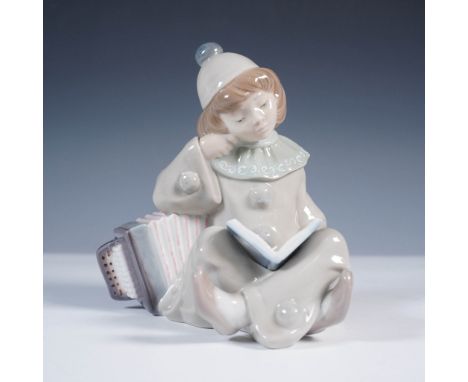 Made in Spain by Lladro, this charming porcelain figurine depicts a thoughtful young clown sitting with an accordion while re