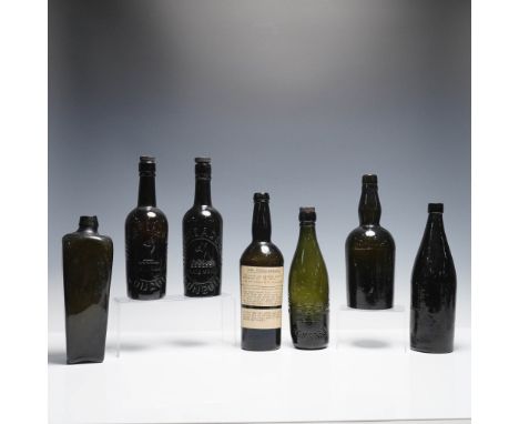 Collection of seven antique glass bottles in varying dark olive and black glass tones. Includes two embossed bottles from Whi