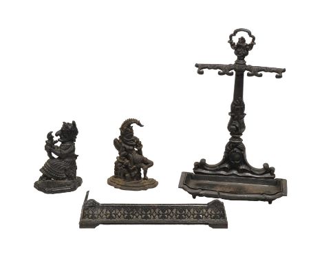 Victorian cast iron stick stand, width 48cm, height 74cm, Punch &amp; Judy cast iron door stops and a small fender.Qty: 4