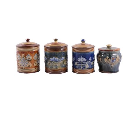 Four Doulton Lambeth stoneware tobacco jars, each modelled in shallow relief with Art Nouveau style flowers and foliage, thre