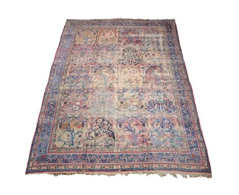 A Persian Lavar Kirman carpet, approximately 380 x 273cm Condition Report: Significant wear to carpet overall with patches of