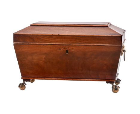 A Regency mahogany tea caddy, circa 1820, of sarcophagus form, the lid enclosing a pair of lidded canisters and an associated