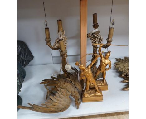 A pair of carved giltwood two branch, three light electric candelabra lamps, a pair of gilt metal Roman warriors and a gilt m