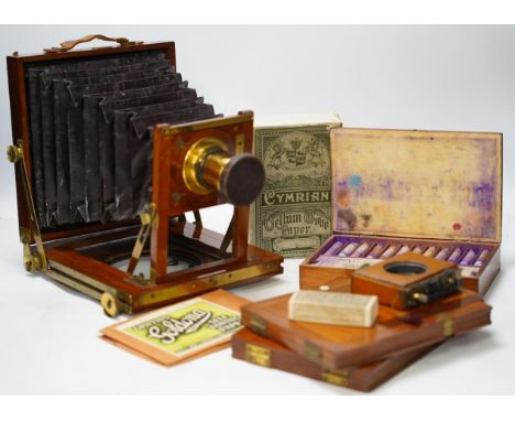 A late 19th century brass and mahogany half plate bellows camera with oak tripod stand and a lens engraved ‘ERR 6.5 x 4.75’, 