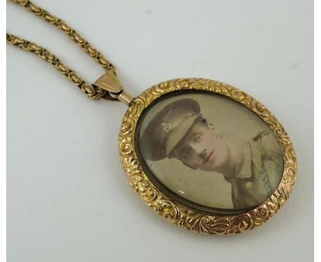 A George V embossed 9ct gold double portrait pendant, 44mm, on a 9ct chain, 37cm, gross weight 30.8 grams. Condition - poor t