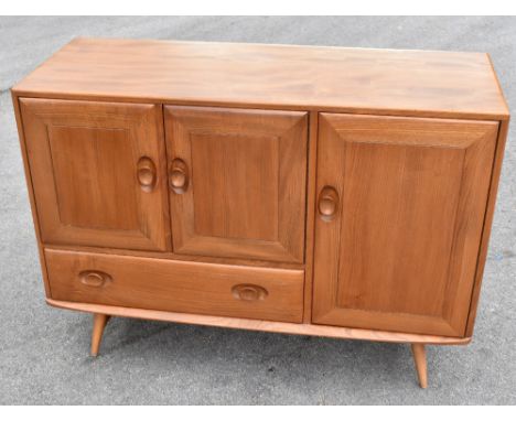 ERCOL; a light elm sideboard, with an arrangement of three cupboard doors and a one long drawer, height 82cm, width 103cm, le