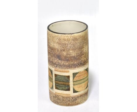 AVRIL BENNETT FOR TROIKA POTTERY; a cylindrical vase decorated with a single band of circles on a brown glazed ground, signed