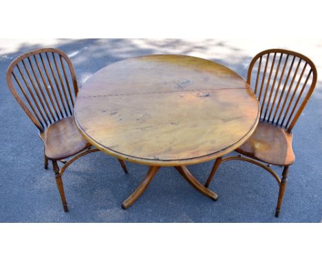 STEWART LINFORD; a reproduction light oak extending dining table with circular top and additional leaf, on carved baluster te