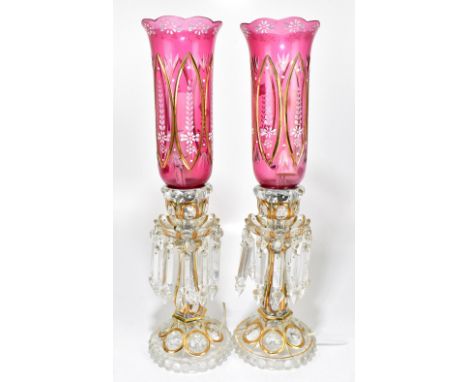 A pair of 20th century Bohemian ruby and clear glass lustre lamps, with storm shaped shades, height 53cm.Additional Informati
