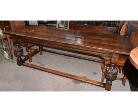 A 17th century style oak refectory dining table, the plank top with cleated ends, on carved and turned baluster legs, height 