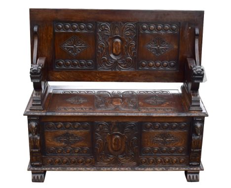 An early 20th century carved and panelled oak monk's bench, width 105cm, depth 46cm, height 71cm.