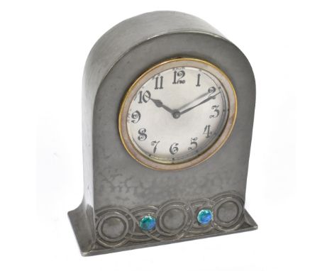 LIBERTY & CO; a pewter and enamel mantel clock, no.01318, the arched case with Arabic numerals to the circular dial and with 
