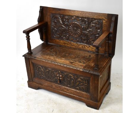 A late Victorian carved oak monk's bench, height 74cm, width 90cm, depth 42cm.&nbsp;