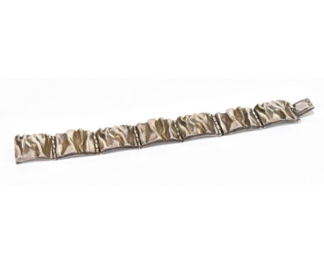 MATTI J HYVARINEN; a Finnish sterling silver textured bracelet with cast decoration, length 17.5cm, approx weight 50.9g.Addit