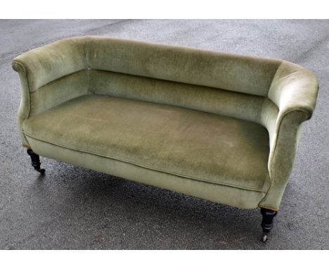 A late Victorian green upholstered sofa on turned ebonised supports, width 162cm, height 71cm, depth 74cm, height of legs 21c