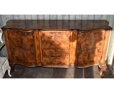 A large European walnut sideboard, with four central drawers flanked by serpentine shaped doors on cabriole supports, width 1