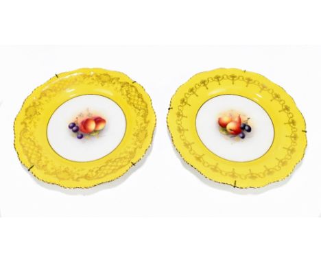 HARRY AYRTON FOR ROYAL WORCESTER; a pair of hand painted cabinet plates with scalloped edges, each decorated with fruits to t