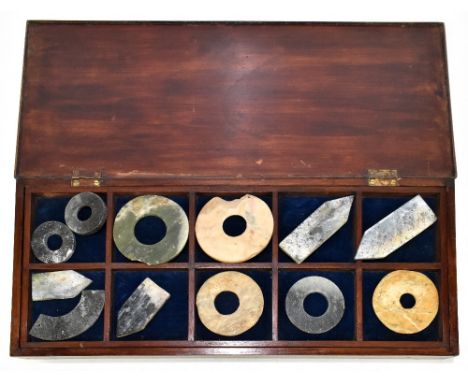 A collection of seven ancient Chinese bi discs and five further jade items all contained in a mahogany cabinet, largest disc 