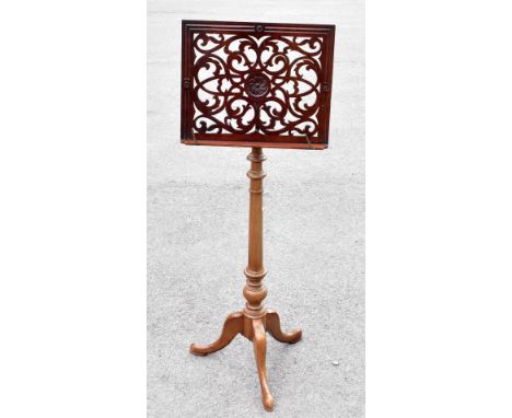 A 19th century and later mahogany and brass music stand, the adjustable upper with carved detailing, height 114cm.Additional 