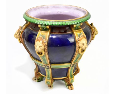 MINTON; a 19th century majolica jardinière moulded with six vertical straps, each with lion mask heads supported on lion paw 