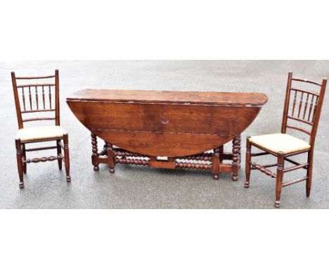 A large reproduction oak oval gateleg dining table or wake table on bobbin turned twin gateleg supports, also a set of eight 