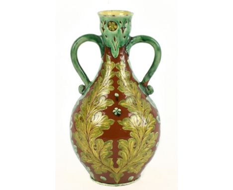 VIOLET WOOHOUSE FOR DELLA ROBBIA: an Art Pottery twin handled baluster shaped vase with floral decoration on a brown ground, 