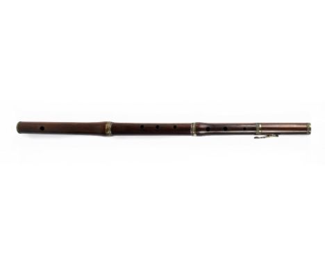 A 19th century rosewood flute with engraved white metal mounts, stamped 'Monzani & Co, 28 Regent Street, Piccadilly, London 1