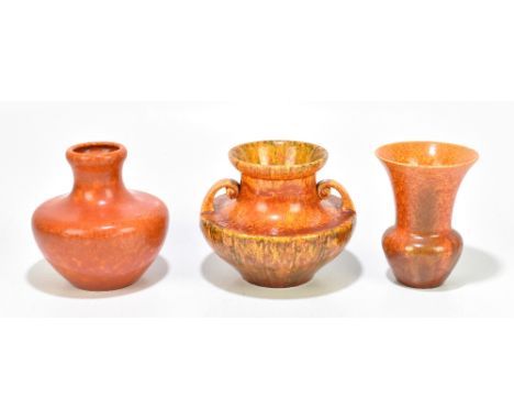 ROYAL LANCASTRIAN; three orange vermillion glazed vases including a twin handled amphora type example with panelled detail, h