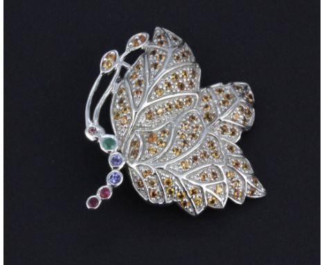 A 925 silver butterfly shaped brooch set with yellow sapphires, emerald, ruby and sapphires, 4 x 3.5cm.