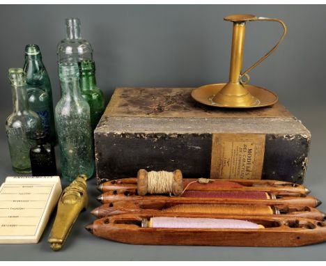 A hammered brass chamber stick, weaving shuttles, glass lemonade bottles and other items.