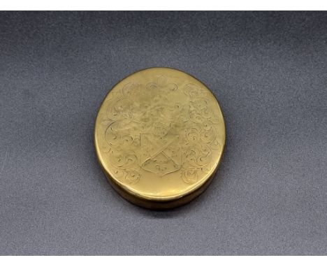 An antique brass oval tobacco box,&nbsp;the lid engraved with the Barrow family crest, the base inscribed 'Christopher Barrow
