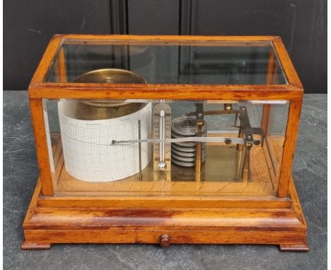 An early 20th century oak barograph, by 'Negretti &amp; Zambra', with bevelled glass and apron drawer, 35.5cm wide.