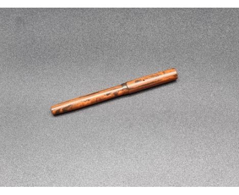 An unusually small early 20th century red ebonite fountain pen, with 14ct gold nib, 9.6cm long.