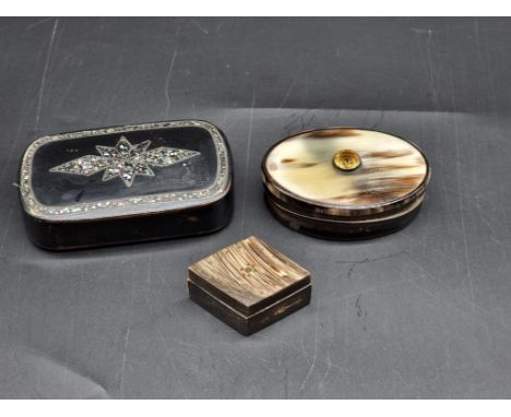 A 19th century papier mache snuff box, 9.5cm wide; together with another horn example, (warped); and another small horn box a