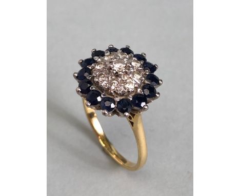 18ct yellow gold Diamond and Sapphire Daisy style ring. A central diamond surrounded by a ring of eight further diamonds, the