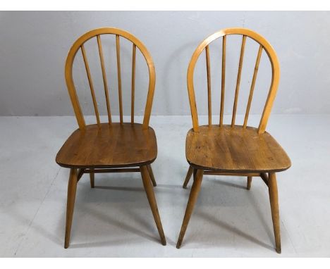 Mid century furniture, two Ercol 1960s blonde hoop back stick dining chairs, registration marks and date to underside of seat