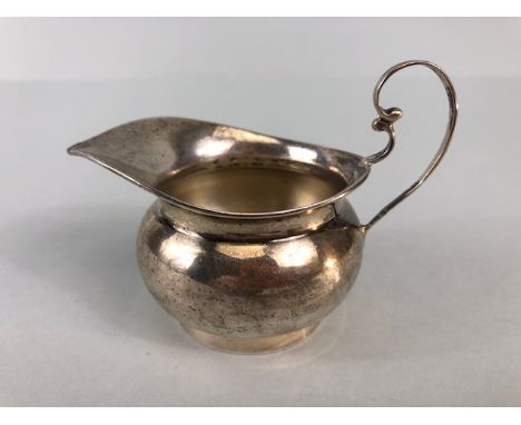 Silver hallmarked creamer on pedestal base with rounded body and scroll handle maker T.W approx 48g