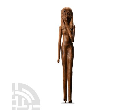 Circa 700 B.C. or earlier. Modelled in the round, standing nude with left leg extended, wearing a tripartite wig with beads t